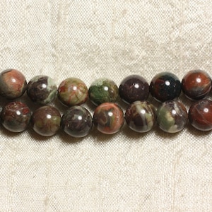 May include: A strand of round, multi-colored beads with brown, green, and red tones. The beads are made of a natural stone with a marbled pattern.