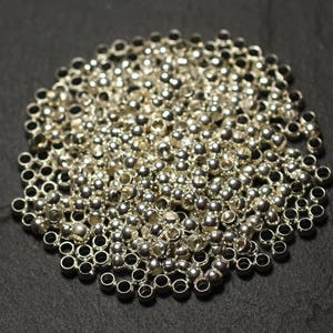 May include: A large pile of silver metal beads, perfect for jewelry making or crafting projects.