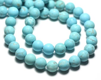 May include: A strand of turquoise blue round beads. The beads are smooth and have a slightly mottled appearance.