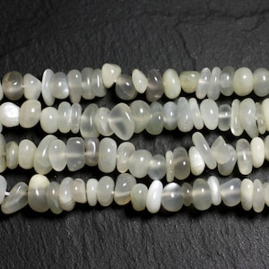 以下が含まれることがあります： 白いムーンストーンビーズのストランド。各ビーズはユニークで不規則な形をしています。ビーズは滑らかで磨かれており、かすかな輝きを放っています。