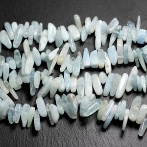 May include: A strand of light blue aquamarine gemstone beads, each bead is a long, irregular, and slightly pointed shape.