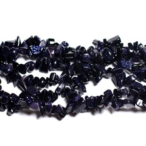 Könnte beinhalten: Eine Strähne dunkelblauer, unregelmäßig geformter Edelsteinchip. Die Chips haben eine glitzernde, funkelnde Textur.