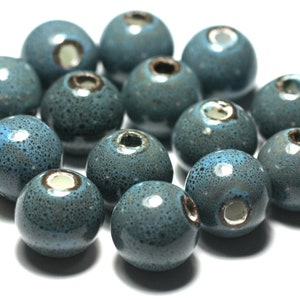 Peut inclure: Un ensemble de 14 perles en céramique bleu sarcelle avec une finition mouchetée. Chaque perle a un trou au centre pour être enfilée.