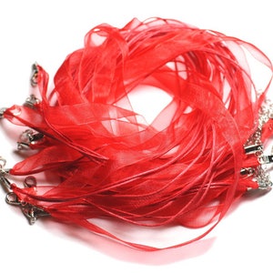 May include: A pile of red ribbon with silver clasps. The ribbon is made of a sheer material and is ideal for crafting or decorating.