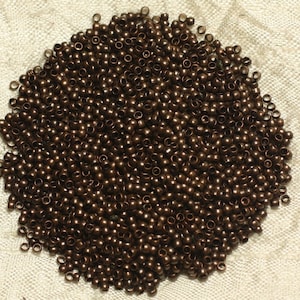 May include: A large pile of small, round, copper-colored beads.