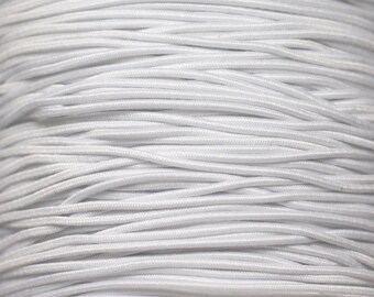 May include: Close-up of a spool of white elastic cord. The cord is tightly wound and has a smooth, matte finish.