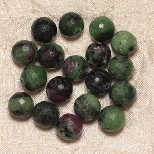 Puede incluir: Una colección de 17 cuentas de piedras preciosas verdes, negras y rosas. Las cuentas son facetadas y tienen forma redonda.