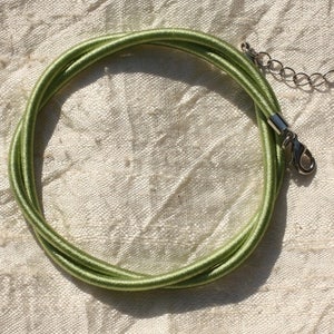 May include: A light green elastic cord necklace with a silver clasp.