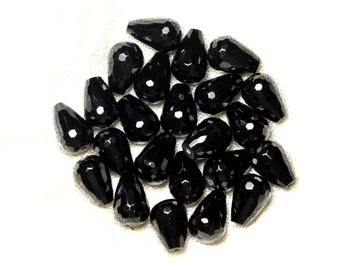 May include: A group of black faceted teardrop-shaped beads. The beads are arranged in a loose pile on a white surface.