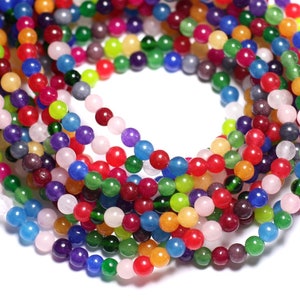 May include: A strand of colorful round beads made of jade. The beads are in various shades of green, blue, red, pink, yellow, and purple.