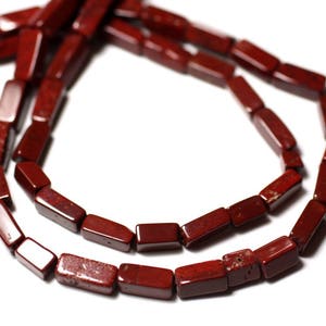 Peut inclure: Un brin de perles de pierres précieuses rouges, chaque perle est de forme prismatique rectangulaire.