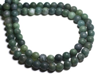 May include: A strand of green agate beads. The beads are round and smooth, and they have a natural, earthy look.