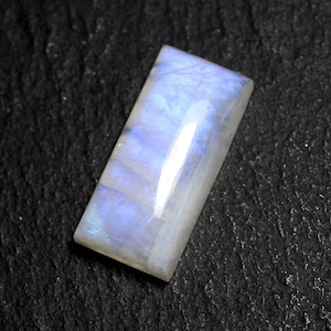 Peut inclure: Un cabochon de pierre de lune rectangulaire et iridescent, de couleur bleu clair et blanc.