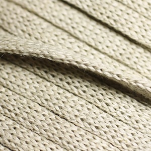 May include: Close-up of a beige woven fabric with a textured surface. The fabric is made of natural fibers and has a subtle sheen.