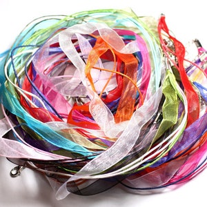 May include: A pile of colourful ribbon and cord, in shades of pink, blue, green, orange, and white. The ribbon is made of a sheer, delicate material.