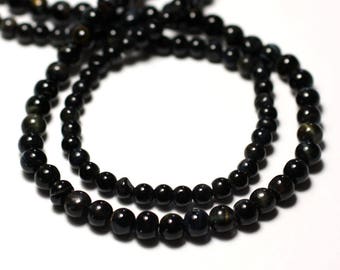 Könnte beinhalten: Eine Kette aus schwarzen Edelsteinperlen mit einem dezenten irisierenden Schimmer. Die Perlen sind rund und gleichmäßig groß, was einen glatten und eleganten Look erzeugt.