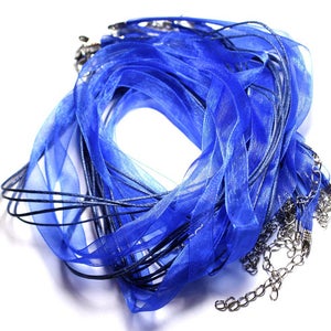 May include: A bundle of blue satin ribbon with silver chains attached. The ribbon is arranged in a circle shape.