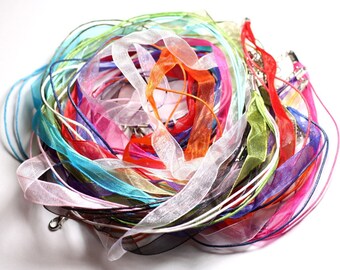 May include: A collection of colorful ribbon and cord in various shades of pink, blue, green, orange, and white. The ribbon is made of a sheer, delicate material.