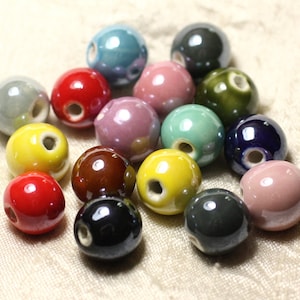 May include: Assortment of colorful ceramic beads with a hole in the center. The beads are various shades of red, yellow, green, blue, brown, and pink.
