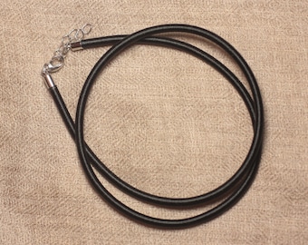 May include: A black cord necklace with a silver-colored clasp and extender chain. The necklace is made of a smooth, round cord and is designed to be worn around the neck. The clasp and extender allow for adjustable sizing.