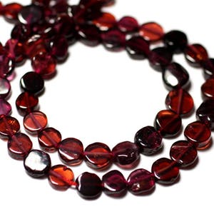 May include: A strand of dark red gemstone beads, each bead is a flat, round, and slightly irregular shape.