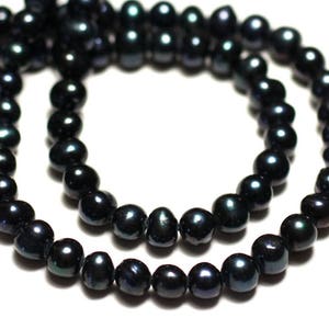 May include: A strand of lustrous, dark-colored pearls, likely cultured, arranged in a necklace or bracelet form. The pearls have a deep, iridescent sheen, reflecting hints of blue and green against a white background. The beads are round and evenly sized.