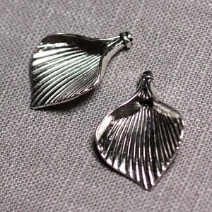 May include: Two silver metal leaf-shaped charms with a textured design.