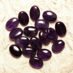Peut inclure: Un groupe de 17 pierres précieuses d'améthyste de forme ovale, chacune avec une teinte violette profonde, sont dispersées sur un fond de tissu blanc.