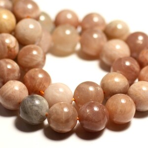 May include: A strand of sunstone beads in shades of peach, orange, and cream. The beads are round and smooth, with a subtle shimmer.