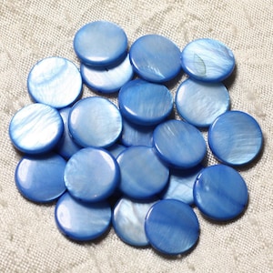 Peut inclure: Un ensemble de perles rondes en nacre bleu clair. Les perles ont un éclat irisé et varient légèrement en teinte. Les perles sont dispersées sur une surface texturée blanc cassé.