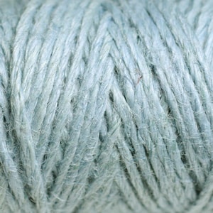 May include: Close-up of a light blue, textured, rope-like material. The material is made of tightly woven strands of fibre.