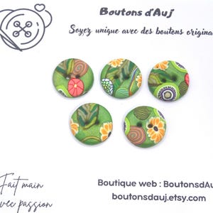 Op de afbeelding: Vijf ronde knopen met een groene basis en veelkleurige bloemen- en wervelpatronen. De afbeelding bevat de tekst Boutons d'Auj, Soyez unique avec des boutons originaux, Fait main Avec passion en het webadres boutonsdauj.etsy.com.