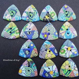 Peut inclure: Une collection de douze boutons triangulaires aux motifs abstraits colorés. Chaque bouton présente un motif unique de tourbillons, de motifs floraux et de formes géométriques dans des tons de bleu, vert, jaune et violet. Les boutons ont deux trous pour la couture.