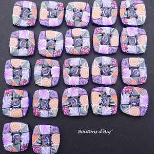 Peut inclure: Vingt-et-un boutons carrés avec un motif patchwork. Chaque bouton présente une spirale centrale entourée de motifs floraux et géométriques dans des tons de violet, orange et noir. Les boutons sont disposés sur une surface sombre.