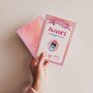 May include: A pink birthday invitation with the text "Olivia's Very Bluey Birthday!" features a cartoon Bluey character. The invitation is held with a matching pink envelope. The invitation includes the time and date of the party.
