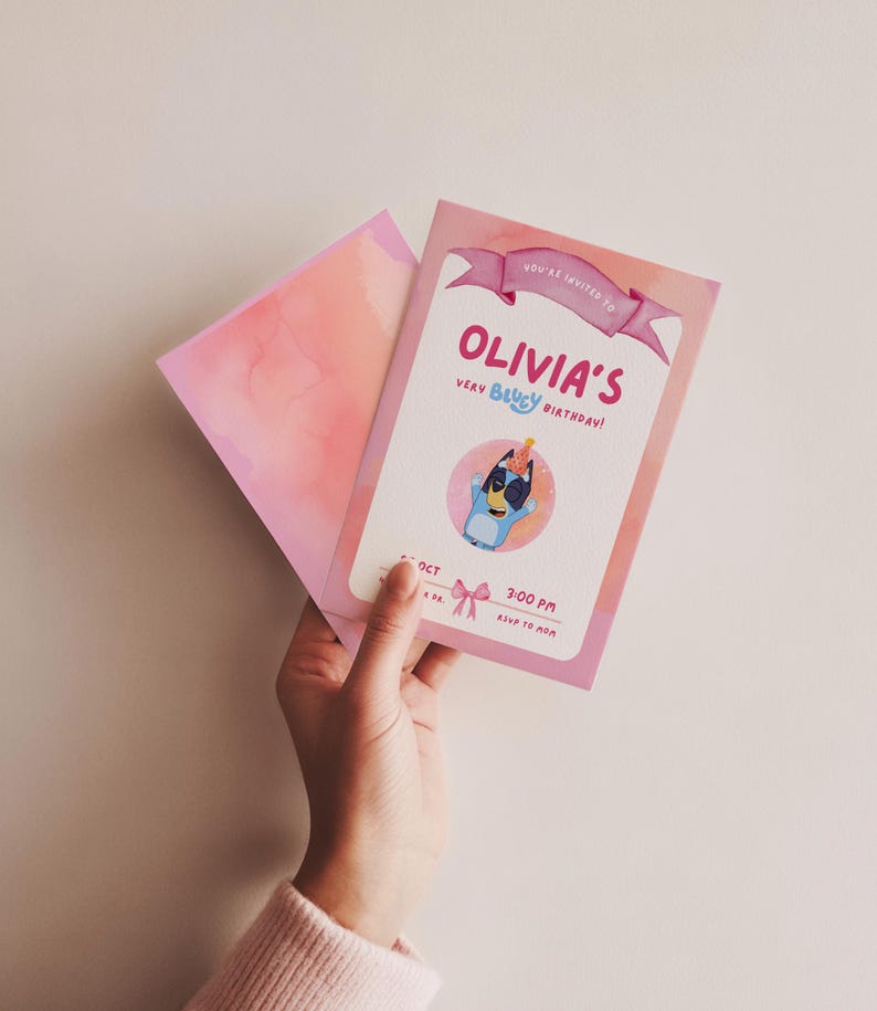 May include: A pink birthday invitation with the text "Olivia's Very Bluey Birthday!" features a cartoon Bluey character. The invitation is held with a matching pink envelope. The invitation includes the time and date of the party.