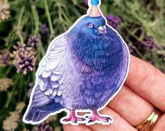 May include: A die-cut sticker featuring a plump pigeon with iridescent blue and purple feathers. The bird is wearing a small, conical party hat with colourful polka dots and a blue pom-pom on top. The pigeon has bright pink feet and a beak.