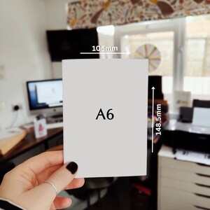 K&ouml;nnte beinhalten: Eine wei&szlig;e Karte mit dem Text "A6" darauf gedruckt. Die Karte ist 105 mm breit und 148,5 mm hoch.
