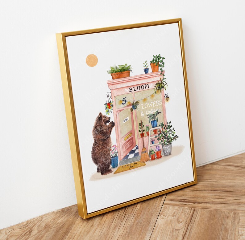 Op de afbeelding: Een aquarelillustratie van een roze winkelgevel met de woorden "Bloom Flowers & Coffee" boven de deur. Een bruine beer staat buiten de winkel en kijkt naar de deur. De winkel heeft een bord met de tekst "Open" en een welkommat met de tekst "Come On In".