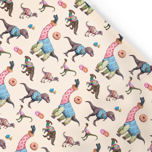 Puede incluir: Un papel de regalo de color crema con un patrón repetido de dinosaurios que llevan suéteres coloridos. Los dinosaurios están en varias poses, incluyendo de pie, caminando y sentados. También hay pequeñas donas y galletas esparcidas por todo el patrón.