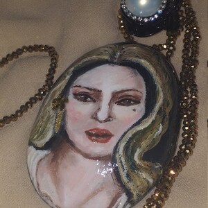 Painting of woman executed with oil colors on stone collected along the seashore