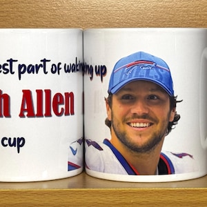May include: A white ceramic mug featuring a photographic print of Josh Allen wearing a blue Buffalo Bills cap and jersey. The text on the mug reads, The best part of waking up Josh Allen on my cup, with the name Josh Allen printed in bold red letters.