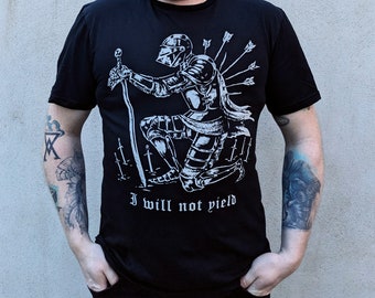 May include: Black t-shirt with a white graphic of a kneeling knight with arrows in his back. The text "I will not yield" is printed below the graphic.