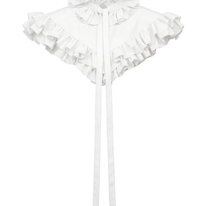May include: A white detachable collar featuring a high ruffled neckline and a wide, layered ruffled capelet design that extends over the shoulders. Two long, narrow white fabric ribbons hang vertically from the center front neckline.