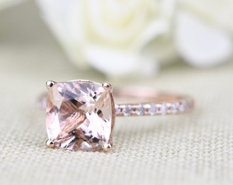 May include: A rose gold engagement ring with a square-shaped, light pink morganite gemstone and a diamond-encrusted band.