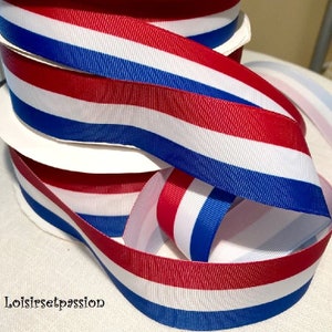 Peut inclure: Ruban rayé rouge, blanc et bleu. Le ruban est fait d'un tissu tissé et a une surface légèrement texturée.