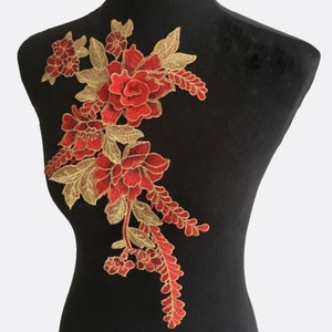 May include: Red and gold floral applique embroidery patch. The design features a large red flower with smaller red flowers and gold leaves.