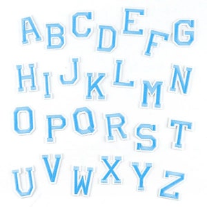Peut inclure: Un ensemble de 26 lettres en feutre bleu clair, chacune avec un contour blanc, représentant l'alphabet anglais. Les lettres sont disposées en ordre alphabétique.
