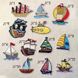 Peut inclure: Douze patchs brodés thermocollants représentant différents types de bateaux, dont un bateau pirate, un sous-marin, un voilier et un bateau de pêche. Les patchs sont numérotés de 1 à 12.