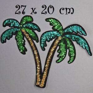 May include: Two green and turquoise palm trees with gold glitter trunks, made of sequins, on a white background. The trees are 27 x 20 cm.
